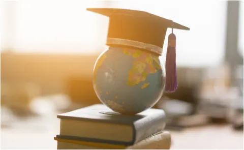 גלובוס על ערימת ספרים עם כובע אקדמיה